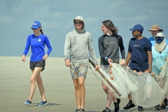 Graduate students holding seine net on the beach.