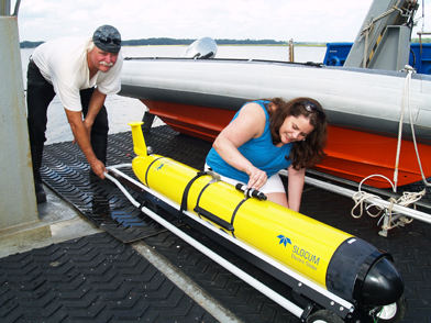 UGA Skidaway Institute scientist Catherine Edwards makes adjustments to the glider “Modena” while R/V Savannah crewman Mickey Baxley assists.