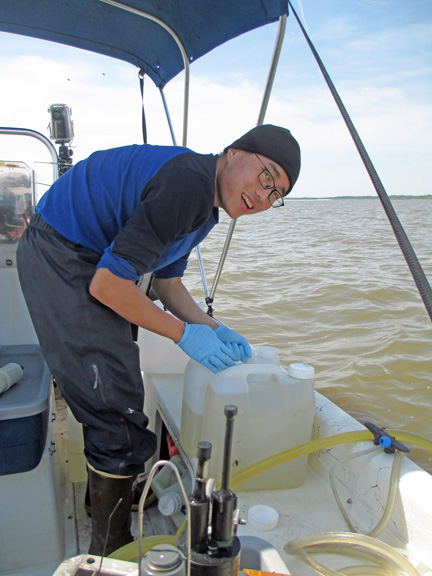 Researcher Lixin Zhu filters larger-volume surface water samples collected from the flow-through system to analyze for dissolved organic carbon.