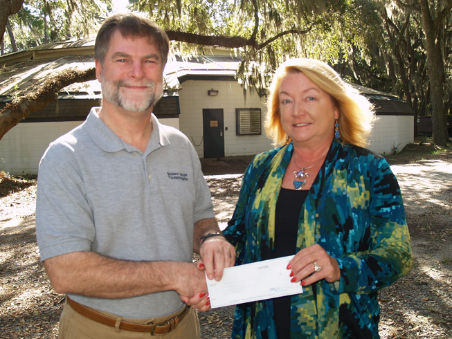 Michelle Vine presents her gift to UGA Skidaway Institute interim director Clark Alexander in front of the soon-to-be-renovated show barn