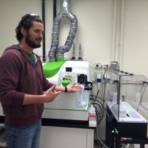 Dr. Buck stands next to the group's ICP-MS.