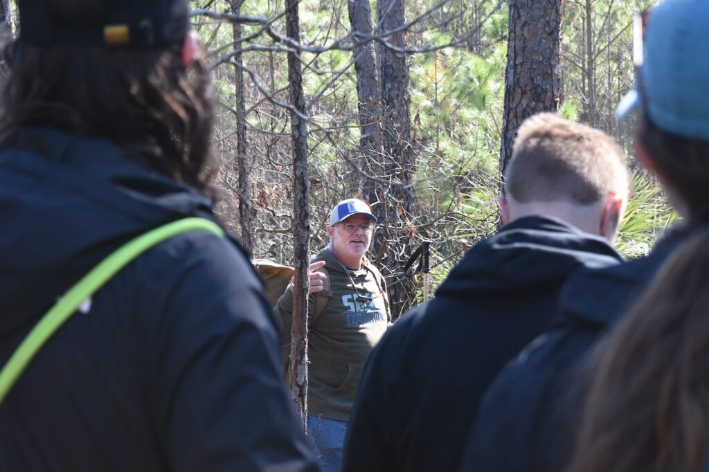 SkIO research professional Mike Robinson (center) talks to students about native plants on Wassaw Island. 