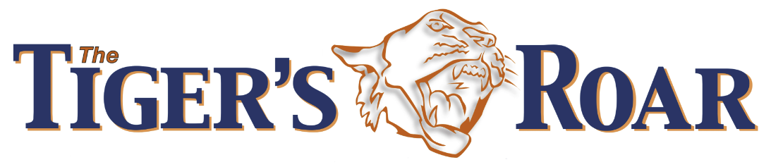 Logo with the words “The Tiger’s Roar” in bold blue and orange letters, featuring the head of a roaring tiger outlined in orange between the words “Tiger’s” and “Roar.”.